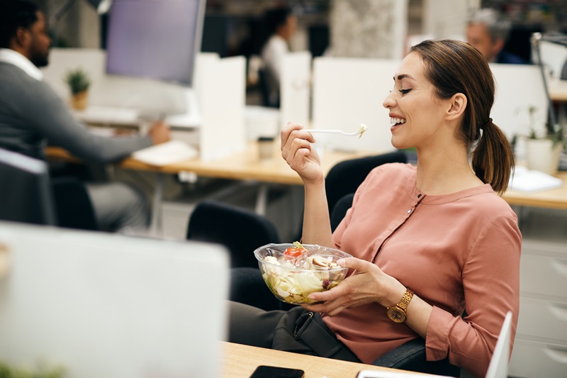 femme-qui-mange-un-repas-rapide-au-travail